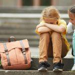 Friend Helping Sad Little Girl in School