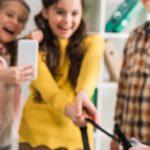panoramic shot of schoolkids bullying schoolgirl in classroom