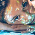 Woman face over hands with sparkles in skin