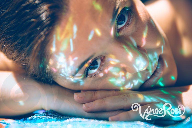 Woman face over hands with sparkles in skin