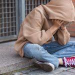 Lonely teenager sitting on the floor outdoors