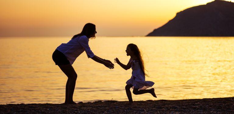 Mother and daughter having fun on beach